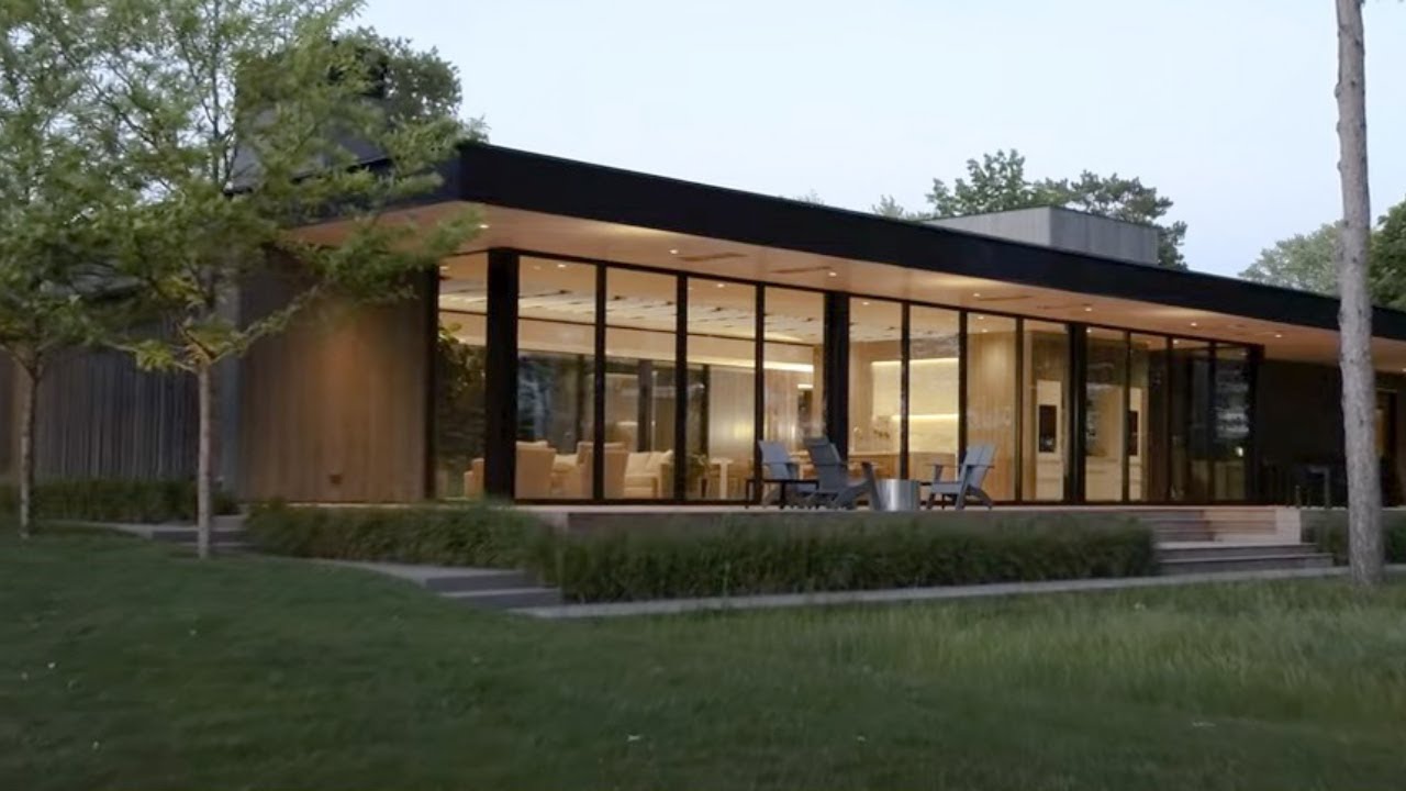 Modern glass house with sleek architectural design, large windows, and contemporary exterior